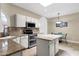 Eat-in kitchen boasts granite countertops, stainless appliances, island, and arched window at 11775 E Becker Ln, Scottsdale, AZ 85259