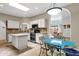 Bright kitchen featuring white cabinetry, an island, stone countertops, and an open view to the living area at 11775 E Becker Ln, Scottsdale, AZ 85259