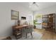 Cozy home office with a wooden desk, shelves, area rug, decor, ceiling fan, and natural light at 11775 E Becker Ln, Scottsdale, AZ 85259