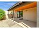 Covered patio with tan walls, gravel landscaping, and sliding glass door to the interior at 11775 E Becker Ln, Scottsdale, AZ 85259