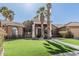 Inviting single-story home featuring lush landscaping, a wide driveway, and a two-car garage at 1207 E Clearview Dr, Casa Grande, AZ 85122
