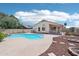 Inviting backyard with a pool, rock waterfall, fire pit, and desert landscaping at 12626 W Windsor Ave, Avondale, AZ 85392