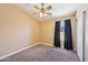 Carpeted bedroom featuring a ceiling fan, window with dark curtains, and a closet at 12626 W Windsor Ave, Avondale, AZ 85392