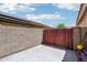 Side yard area enclosed with a tall block wall and a wood gate at 12626 W Windsor Ave, Avondale, AZ 85392