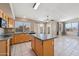 Open concept kitchen featuring an island, stainless appliances, tile backsplash, and backyard access at 12626 W Windsor Ave, Avondale, AZ 85392