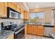 This kitchen features wooden cabinets, granite countertops, stainless steel appliances, and tile flooring at 12626 W Windsor Ave, Avondale, AZ 85392