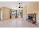 Spacious living area featuring a brick fireplace, tile flooring, and large windows with coverings at 12626 W Windsor Ave, Avondale, AZ 85392