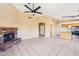 Spacious living area featuring a brick fireplace and tile flooring with access to kitchen and hall at 12626 W Windsor Ave, Avondale, AZ 85392