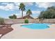 Backyard pool with tropical palms, a rock waterfall, and mature landscaping at 12626 W Windsor Ave, Avondale, AZ 85392