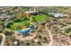 Aerial view of community amenities: a community center, pool, playground, and lush green park at 12702 W Dove Wing Way, Peoria, AZ 85383