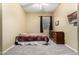 Cozy bedroom features neutral color paint, window with brown curtains, and bed at 12702 W Dove Wing Way, Peoria, AZ 85383