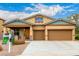 Inviting home featuring a three-car garage, covered porch, xeriscaping, and 'For Sale' sign at 12702 W Dove Wing Way, Peoria, AZ 85383