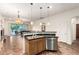 Kitchen with an island, stainless steel appliances, including dishwasher, and an opening to the living area at 12702 W Dove Wing Way, Peoria, AZ 85383