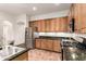 A modern kitchen with stainless steel appliances, wood cabinets, and granite countertops at 12702 W Dove Wing Way, Peoria, AZ 85383