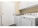 Functional laundry room featuring a washer, dryer, and overhead cabinets at 12702 W Dove Wing Way, Peoria, AZ 85383