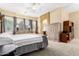 Main bedroom boasts natural light through three windows, complementing neutral walls and carpeted flooring at 12702 W Dove Wing Way, Peoria, AZ 85383