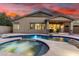 Backyard pool and spa are surrounded by stone decking, providing a luxurious outdoor space at 12702 W Dove Wing Way, Peoria, AZ 85383