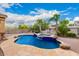 Inviting backyard pool and spa area with mature palm trees, rock features, and private fencing at 12702 W Dove Wing Way, Peoria, AZ 85383