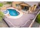 Aerial view of a backyard oasis featuring a pristine pool, spa, and an expansive stone patio at 12702 W Dove Wing Way, Peoria, AZ 85383