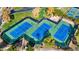 Aerial view of well-maintained tennis courts with blue playing surfaces and lush green surroundings at 12702 W Dove Wing Way, Peoria, AZ 85383