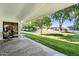 Covered patio overlooking lush green backyard, perfect for outdoor relaxation and entertaining in serene setting at 12726 W Copperstone Dr, Sun City West, AZ 85375