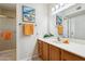 Bathroom vanity featuring framed mirror, decorative sconces, with bright orange hand towels at 12726 W Copperstone Dr, Sun City West, AZ 85375