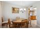 Bright dining area features a wooden table with seating for four, set beneath an elegant chandelier at 12726 W Copperstone Dr, Sun City West, AZ 85375