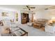 Comfortable living room with plush carpeting, a ceiling fan, and plenty of seating at 12726 W Copperstone Dr, Sun City West, AZ 85375