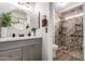 Bathroom featuring marble countertops, a stylish vanity, and walk-in shower with granite walls at 15047 W Kings Dr, Surprise, AZ 85374