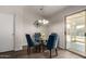Bright dining area with wood floors, modern light fixture, and sliding glass door to the sunroom at 15047 W Kings Dr, Surprise, AZ 85374