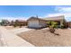 Charming single-story home with desert landscaping, a two-car garage, and an American flag at 15047 W Kings Dr, Surprise, AZ 85374