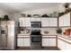 Kitchen featuring stainless steel appliances, white cabinets with wood trim, and marble countertops at 15047 W Kings Dr, Surprise, AZ 85374