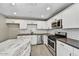 Modern kitchen with white cabinetry, stainless steel appliances, and a stylish marble-topped island at 15049 N 25Th Pl, Phoenix, AZ 85032