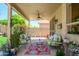 Relaxing covered patio with comfortable seating, ceiling fan, and lush green plants at 17710 W Buena Vista Dr, Surprise, AZ 85374