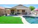 Charming backyard pool with well-manicured lawn and covered patio area perfect for entertaining at 17710 W Buena Vista Dr, Surprise, AZ 85374