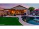 Inviting backyard featuring a pool, artificial grass, and a covered patio at 17710 W Buena Vista Dr, Surprise, AZ 85374