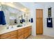 Bathroom with double sinks, wood cabinets, and a large mirror at 17710 W Buena Vista Dr, Surprise, AZ 85374