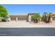 Attractive home with a two-car garage, well-kept lawn, and mature palm trees in the front yard at 17710 W Buena Vista Dr, Surprise, AZ 85374