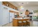 The eat-in kitchen has wood cabinets, tile floors, and a kitchen island with barstool seating at 17710 W Buena Vista Dr, Surprise, AZ 85374