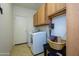 Well-equipped laundry room with washer, dryer, and cabinet space for efficient organization at 17710 W Buena Vista Dr, Surprise, AZ 85374