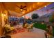 Outdoor patio with comfortable seating, ceiling fan, string lighting, and a view of the pool and backyard at 17710 W Buena Vista Dr, Surprise, AZ 85374