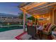 Outdoor dining area featuring a furnished patio with string lights overlooking the backyard pool at 17710 W Buena Vista Dr, Surprise, AZ 85374