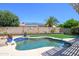Sparkling pool with a lush green lawn and a privacy wall adorned with charming decorations at 17710 W Buena Vista Dr, Surprise, AZ 85374