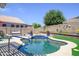Inviting pool area with manicured landscaping, cozy seating, and privacy fencing at 17710 W Buena Vista Dr, Surprise, AZ 85374