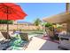 Relaxing poolside featuring comfortable lounge chairs and an umbrella for shade on a sunny day at 17710 W Buena Vista Dr, Surprise, AZ 85374