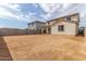 Back exterior of home shows covered patio, backyard space, neutral stucco, and clay tile roof at 18383 W Monte Lindo Ln, Surprise, AZ 85387