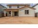 Back exterior of home shows covered patio, backyard space, neutral stucco, and clay tile roof at 18383 W Monte Lindo Ln, Surprise, AZ 85387
