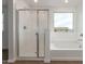 Bright bathroom with a large tub and glass shower, with a window view at 18383 W Monte Lindo Ln, Surprise, AZ 85387