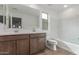 Well-lit bathroom featuring a double sink, wood cabinets, and a shower-tub combo at 18383 W Monte Lindo Ln, Surprise, AZ 85387