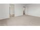Well-lit carpeted bedroom featuring white walls, baseboards, and multiple doorways at 18383 W Monte Lindo Ln, Surprise, AZ 85387